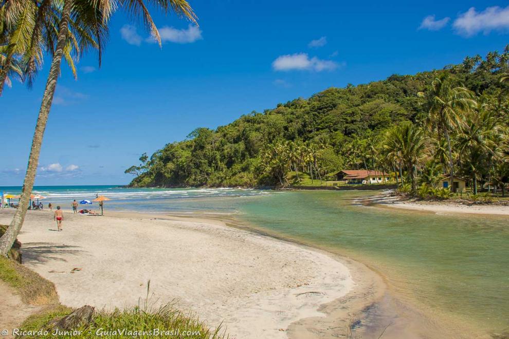 Imagem de turistas entre o mar e a piscina natural da Praia de Jeribucaçu.